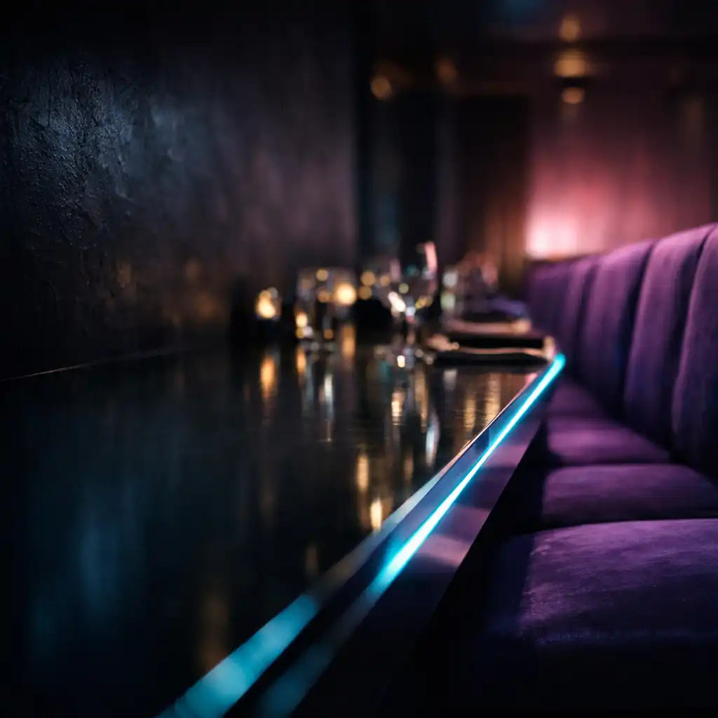 Reflective dining table edge, violet seating and restrained neon architectural light